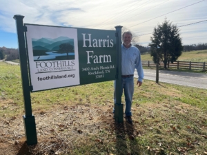 FLC Executive Director, Bill Clabough, stands next to the new Foothills & Harris Farm sign at the office headquarters in Rockford, TN.